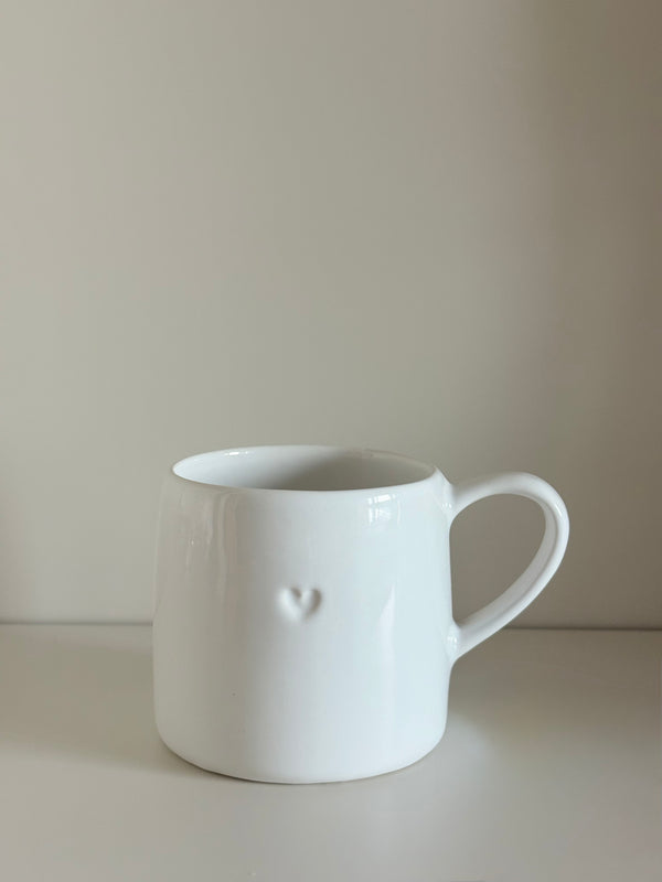 Taza blanca con corazón en relieve