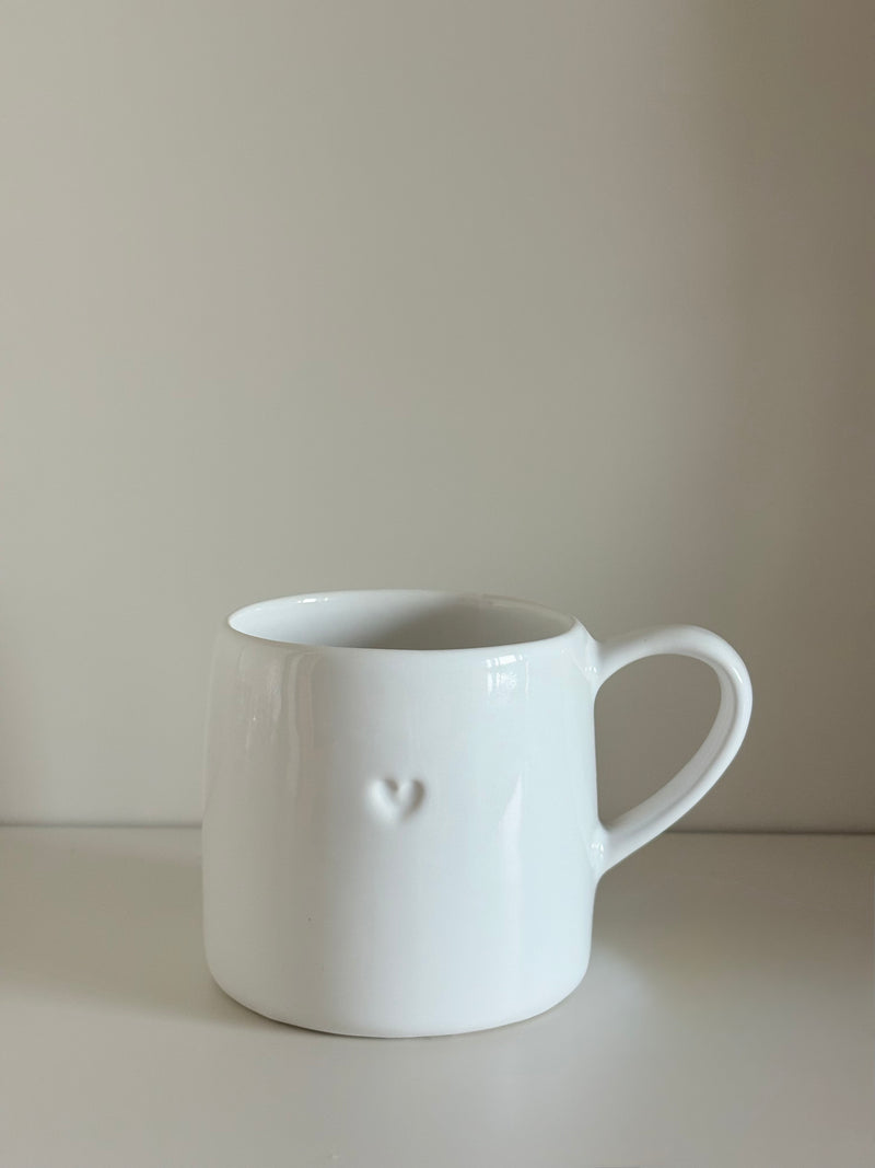 Taza blanca con corazón en relieve