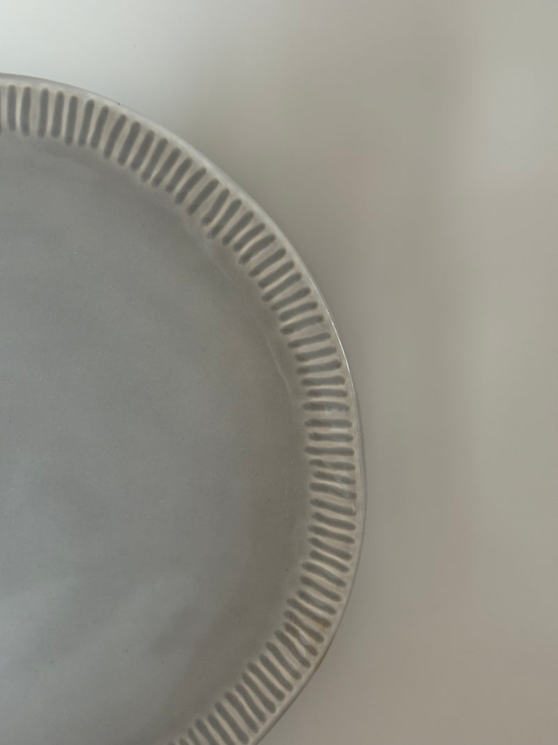 Plato gris con greca en relieve